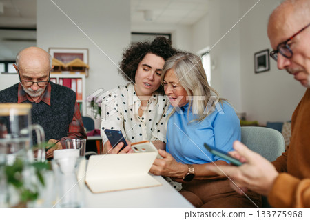 Tutor teaching seniors about phone scams and digital safety. 133775968