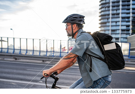 Male cyclist riding bike down the street. Male cyclist riding bike down the street. 133775973