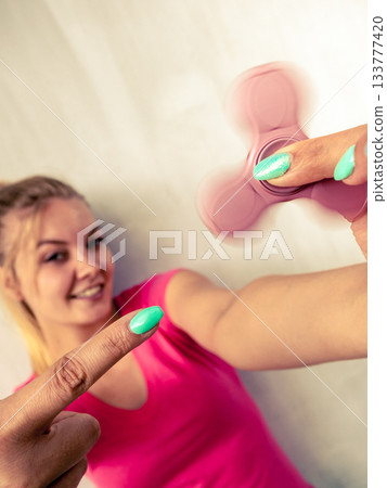 Woman playing fidget spinner 133777420