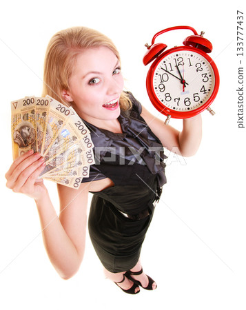Woman holding polish money banknote and alarm clock. 133777437
