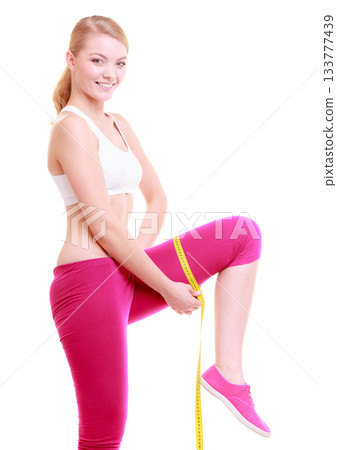 Fitness woman fit girl with measure tape measuring her thigh 133777439