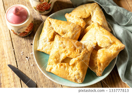 Puff pastry patties with mushroom and cheese filling on a rustic background. Puff pastry patties with mushroom and cheese filling on a rustic background. 133777813