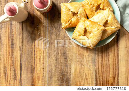 Puff pastry patties with mushroom and cheese filling on a rustic background. Top view. Puff pastry patties with mushroom and cheese filling on a rustic background. Top view. 133777818