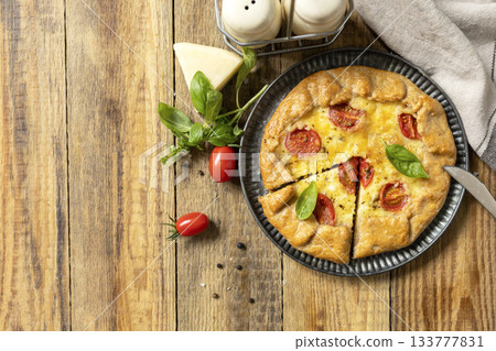 Crispy tomato galette with adyghe cheese and herbs on rustic background. Top view. 133777831
