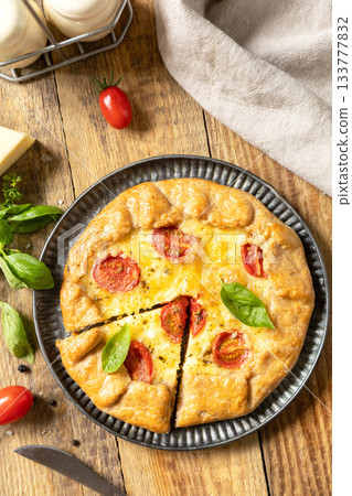 Crispy tomato galette with adyghe cheese and herbs on rustic background. Top view. 133777832