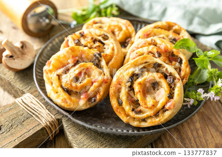 Puff pastry rolls with mushroom and cheese filling on rustic background. Puff pastry rolls with mushroom and cheese filling on rustic background. 133777837