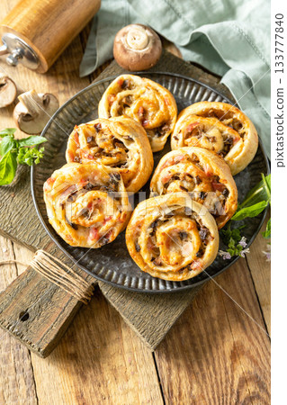Puff pastry rolls with mushroom and cheese filling on rustic background. Puff pastry rolls with mushroom and cheese filling on rustic background. 133777840