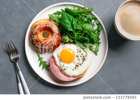 Healthy breakfast. Bagel sandwich with fried egg, ham and greens Healthy breakfast. Bagel sandwich with fried egg, ham and greens 133778565