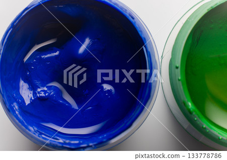 Bright blue paint, macro shot of gouache paint texture. Open paint on a white table, a drawing and creative tool 133778786