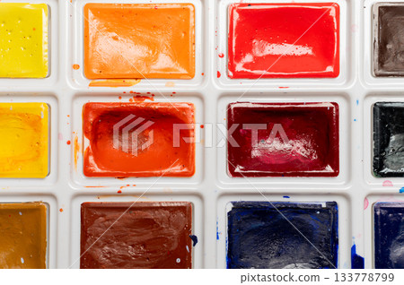 Close-up of a palette with multi-colored paints in a box, new but already used, open paints for creativity 133778799