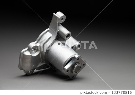 High-quality spare parts for your car. Car maintenance. New water pump for the engine cooling system on a gray gradient background. 133778816