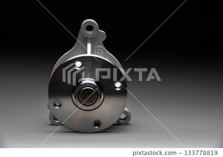 High-quality spare parts for your car. Car maintenance. New water pump for the engine cooling system on a gray gradient background. High-quality spare parts for your car. Car maintenance. New water pump for the engine cooling system on a gray gradient background. 133778819
