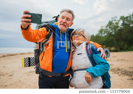 Hiking tourism adventure. Senior couple making selfie enjoying outdoor recreation hiking. Old people backpackers hikers taking photo enjoy walking hike trekking active vacation beauty of nature 133779009