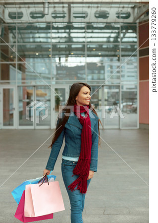 Young woman with shopping bags walking out from shop.Woman in shopping. Consumerism, shopping, Young woman with shopping bags walking out from shop.Woman in shopping. Consumerism, shopping, 133779260