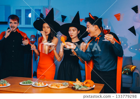 Joyful office Halloween party with coworkers in costumes, celebrating with drinks and laughter, fostering teamwork and festive spirit 133779298