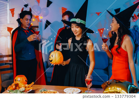 Joyful office Halloween party with coworkers in costumes, celebrating with drinks and laughter, fostering teamwork and festive spirit Joyful office Halloween party with coworkers in costumes, celebrating with drinks and laughter, fostering teamwork and festive spirit 133779304