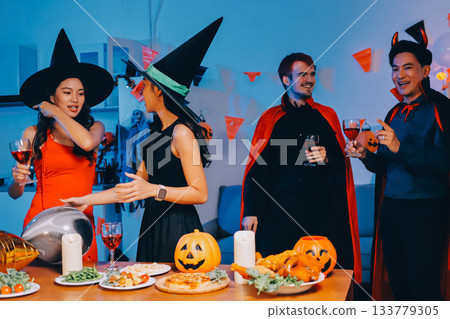 Joyful office Halloween party with coworkers in costumes, celebrating with drinks and laughter, fostering teamwork and festive spirit Joyful office Halloween party with coworkers in costumes, celebrating with drinks and laughter, fostering teamwork and festive spirit 133779305