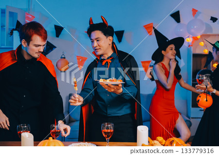 Joyful office Halloween party with coworkers in costumes, celebrating with drinks and laughter, fostering teamwork and festive spirit 133779316