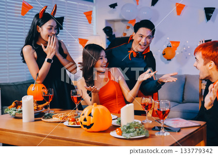 Joyful office Halloween party with coworkers in costumes, celebrating with drinks and laughter, fostering teamwork and festive spirit 133779342