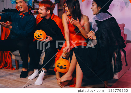 Joyful office Halloween party with coworkers in costumes, celebrating with drinks and laughter, fostering teamwork and festive spirit 133779360