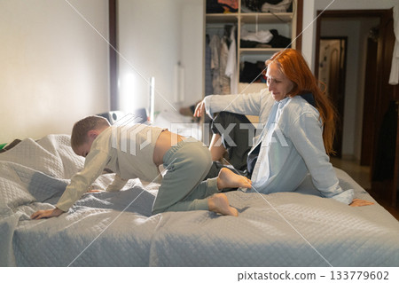 Mother and son bonding on bed at home Mother and son bonding on bed at home 133779602