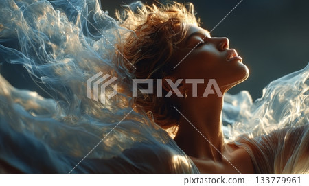 Side view of a beautiful woman's profile bathed in golden sunlight, with her hair and fabric flowing in a translucent, smoke-like texture. 133779961