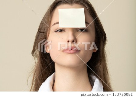 Woman with yellow sticker note on her forehead Woman with yellow sticker note on her forehead 133780091