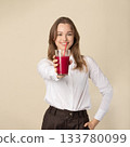 Beautiful woman drinking red juice with straw 133780099