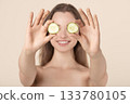 Beautiful young woman covering her eyes with cucumber slices 133780105