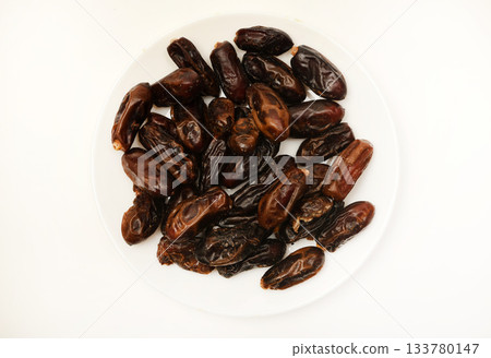 Juicy dates on a plate. Dried fruits. Sweet dried fruits. Juicy dates on a plate. Dried fruits. Sweet dried fruits. 133780147