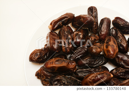 Juicy dates on a plate. Dried fruits. Sweet dried fruits. Juicy dates on a plate. Dried fruits. Sweet dried fruits. 133780148