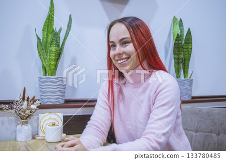 Smiling young woman with red hair in a cozy coffee shop. 133780485