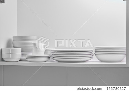 White minimalist dishware stacking inside kitchen cabinet White minimalist dishware stacking inside kitchen cabinet 133780827