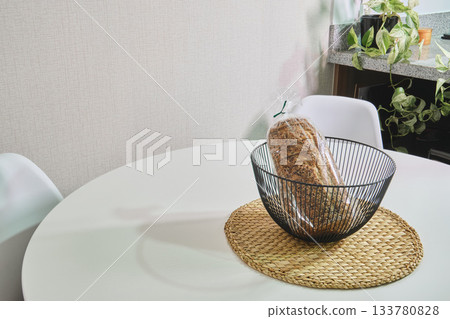 Whole grain bread in basket on modern kitchen table 133780828