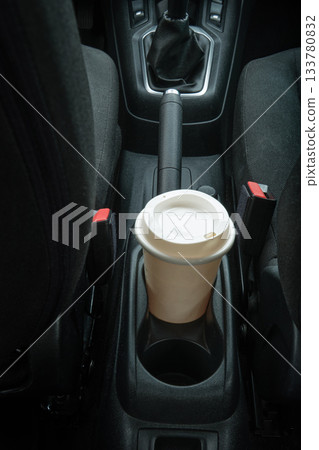 Coffee cup in car holder while traveling Coffee cup in car holder while traveling 133780832