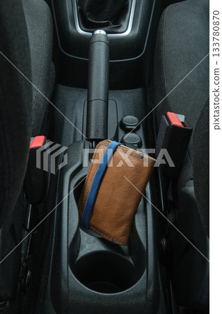 Leather wallet resting in car console cup holder Leather wallet resting in car console cup holder 133780870