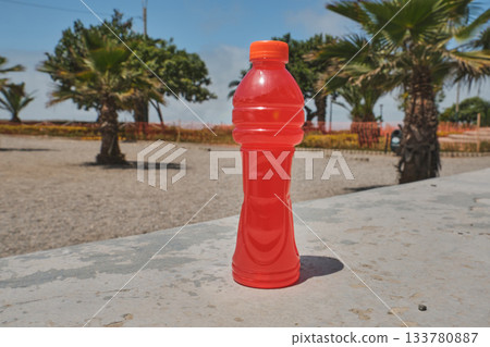 Red plastic sports drink bottle refreshing outdoors Red plastic sports drink bottle refreshing outdoors 133780887