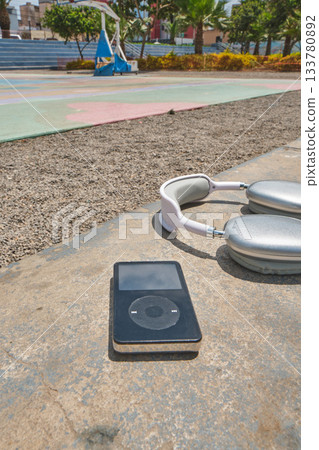 Retro player music and headphones on sunny basketball court Retro player music and headphones on sunny basketball court 133780892