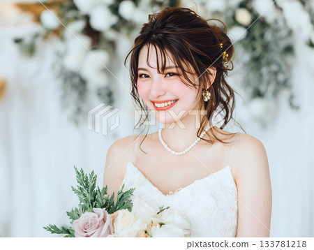 一位美麗的日本新娘穿著純白婚紗，笑容燦爛。 133781218