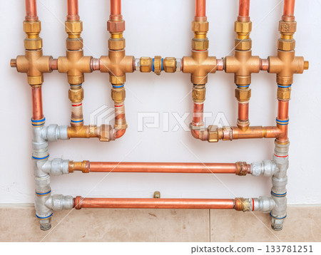 住宅熱水管路系統的結構圖,圖中整齊排列著銅管和閥門。 住宅熱水管路系統的結構圖,圖中整齊排列著銅管和閥門。 133781251