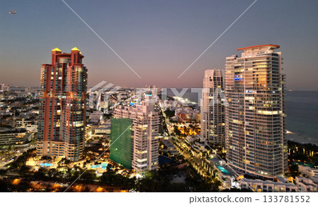 Miami South beach night light. Aerial skyscraper cityscape at night. Night city aerial view. Luxury skyscraper in Miami, Florida. City skyline in evening. Aerial cityscape. Illuminated architecture Miami South beach night light. Aerial skyscraper cityscape at night. Night city aerial view. Luxury skyscraper in Miami, Florida. City skyline in evening. Aerial cityscape. Illuminated architecture 133781552
