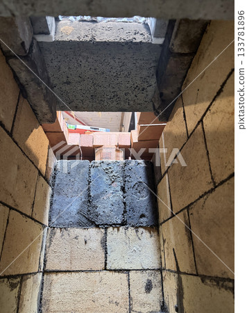 Installation of the heating stove ceiling with concrete slabs. View from inside the firebox. Construction of a heating stove. Installation of the heating stove ceiling with concrete slabs. View from inside the firebox. Construction of a heating stove. 133781896