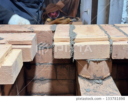 Brickwork of a heating stove. Channels for dividing and passing smoke. Close-up. 133781898