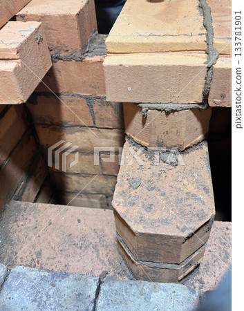 Brickwork of a heating stove. Channels for dividing and passing smoke. Close-up. Brickwork of a heating stove. Channels for dividing and passing smoke. Close-up. 133781901