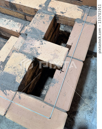 Brickwork of a heating stove. Reinforced with steel wire. Brickwork of a heating stove. Reinforced with steel wire. 133781911