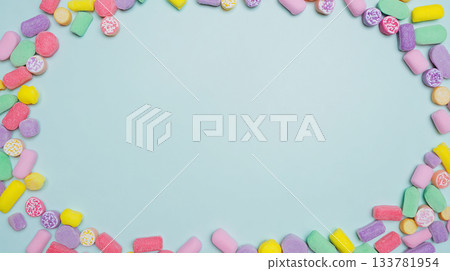 photo styling in a form of a candy frame border on a white background with copy space for text, colorful pastel birthday party decorations in a flat lay style, isolated on a light grey background.  133781954