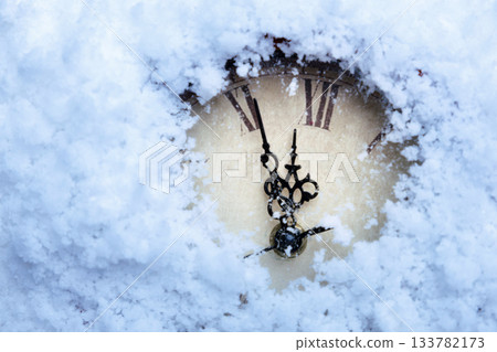 A clock with Roman numerals in the snow. A clock with Roman numerals in the snow. 133782173