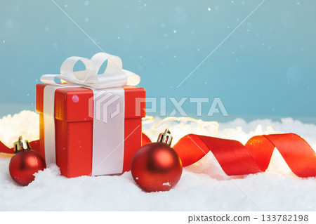 Gift box on snow with two baubles, copy space Gift box on snow with two baubles, copy space 133782198