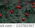 Christmas tree decorated with red holiday ornaments 133782367