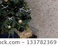 Gifts under a Christmas tree decorated with bows and holiday ornaments 133782369
